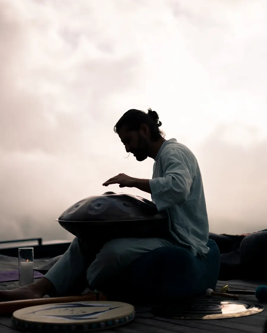 Silueta tocando handpan al atardecer